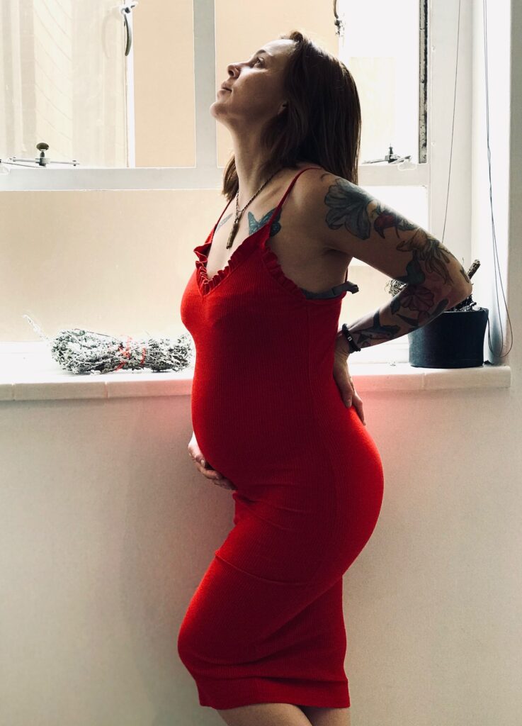 pregnant woman holding her belly and low back at the same time